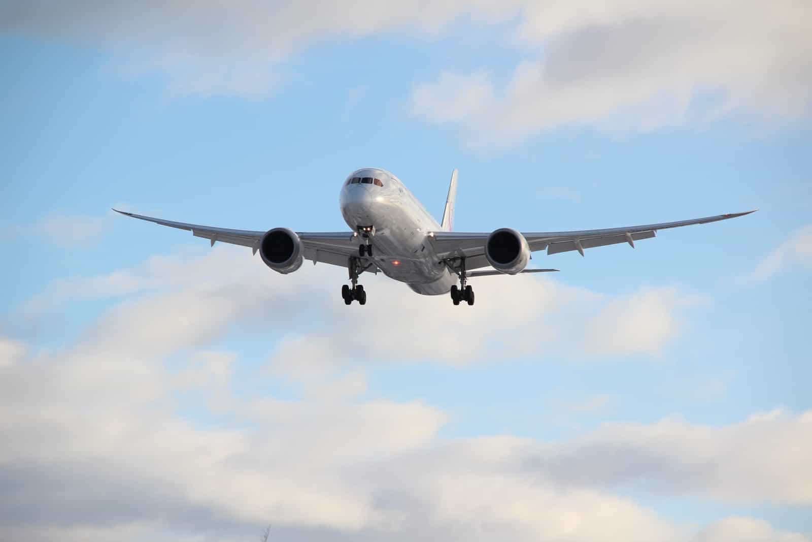 white passenger plane in mid air during daytime