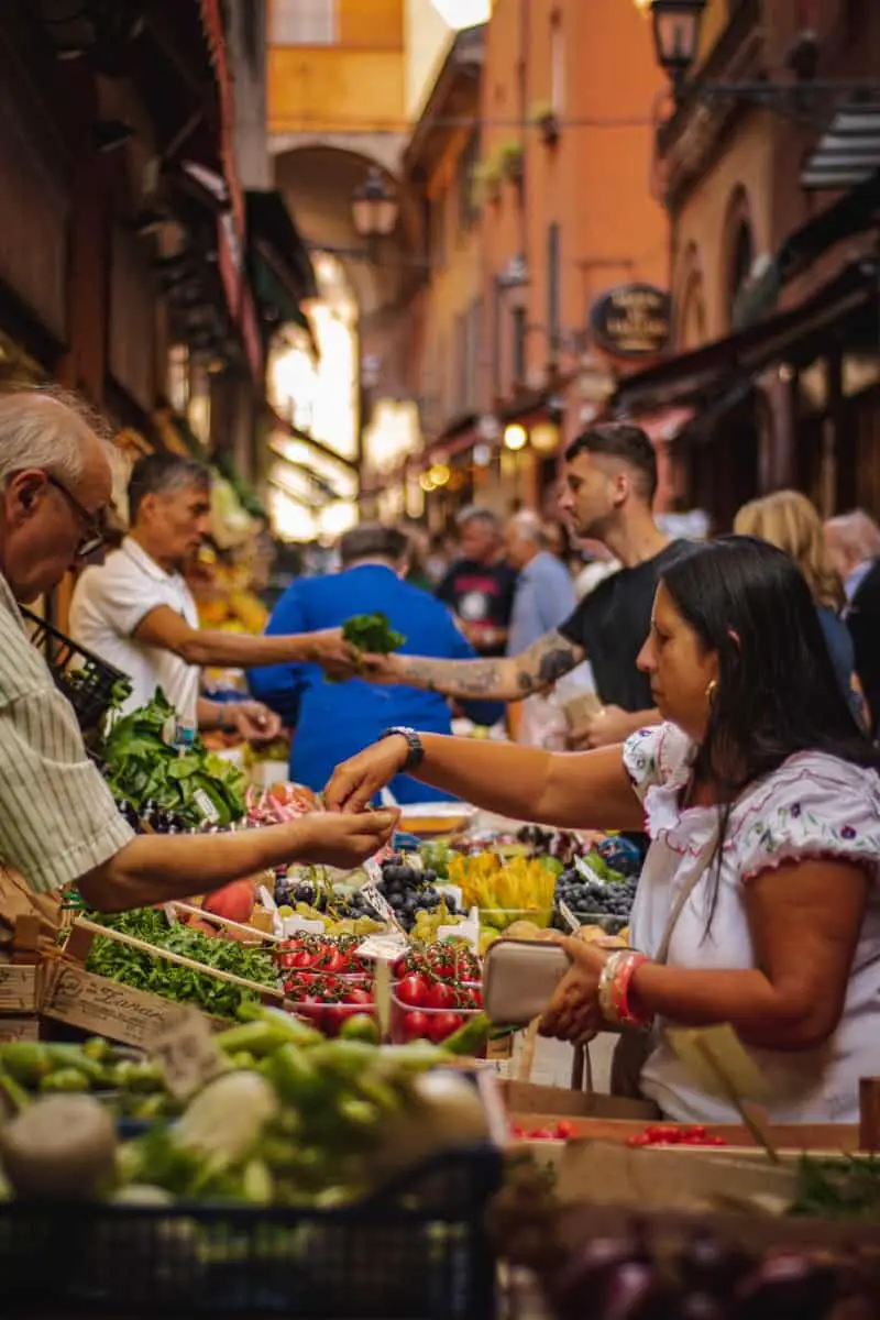 woman wearing white and red blouse buying some veggies