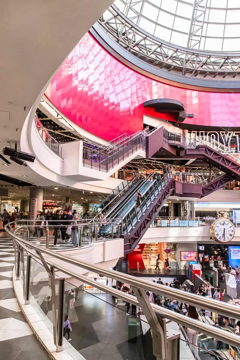 people walking inside building with escalator