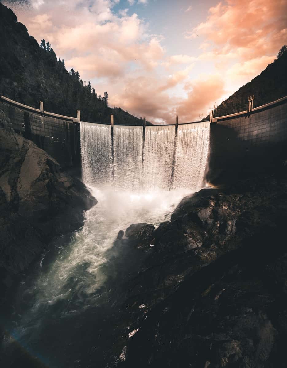 grayscale photo of waterfalls under cloudy sky