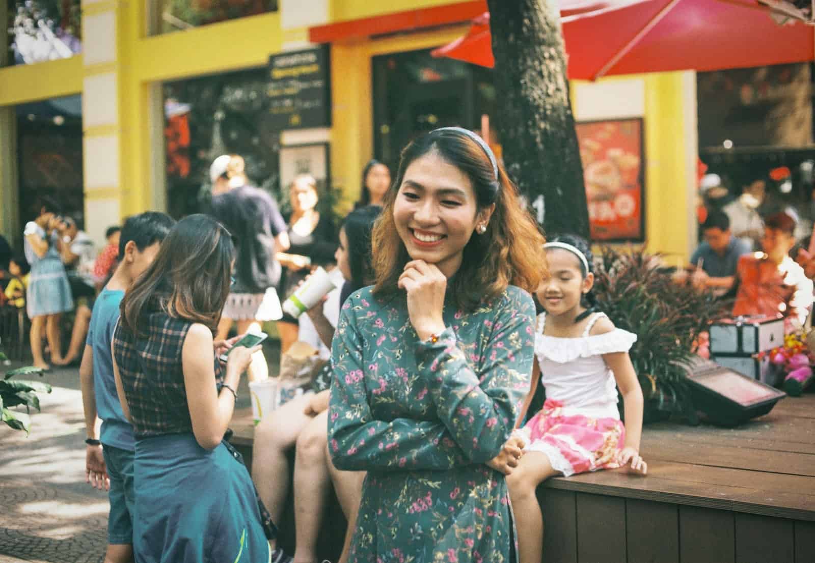 smiling woman standing front of people at daytime