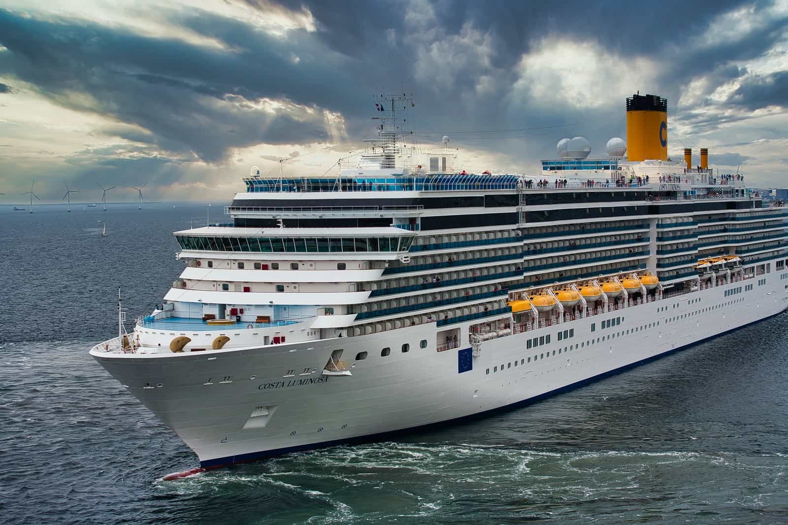 white cruise ship on sea under white clouds and blue sky during daytime