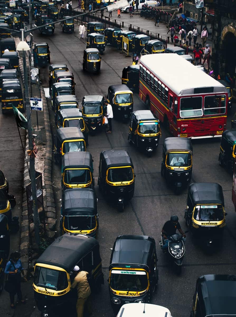 black-and-yellow auto rickshaw on road