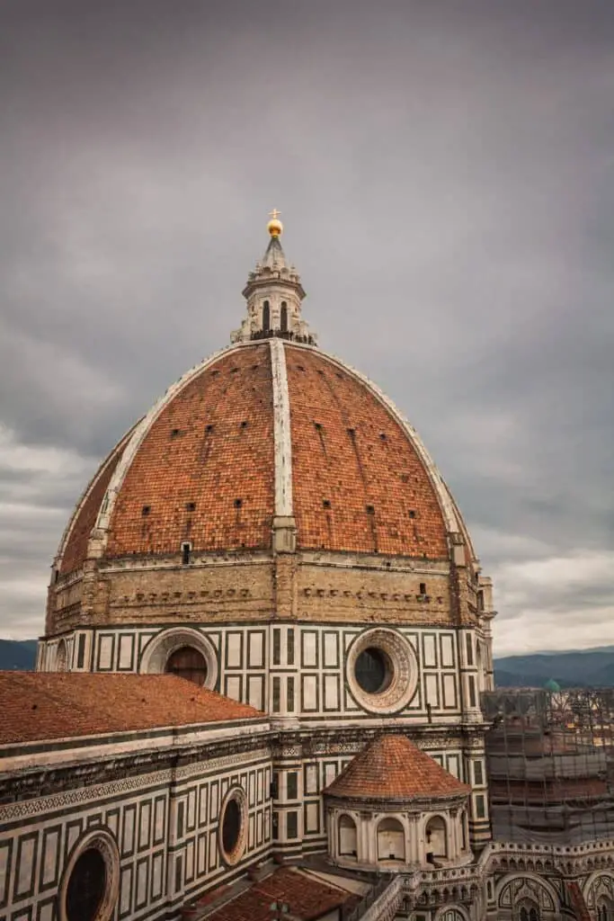 brown dome building under gray clouds