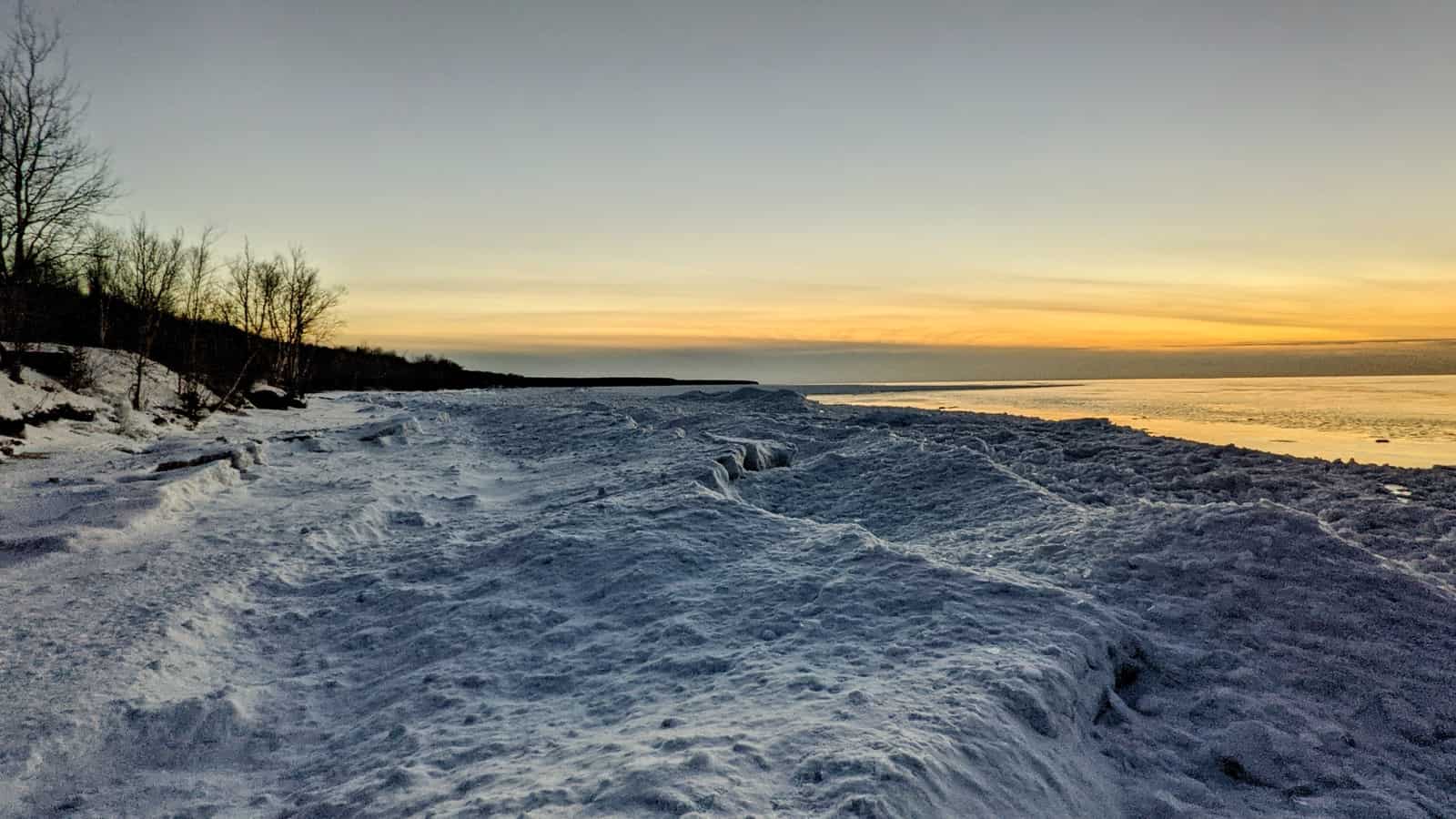 ocean waves crashing on shore during sunset