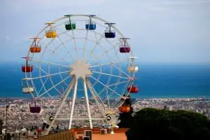 multicolored Ferris wheel facing cityscape