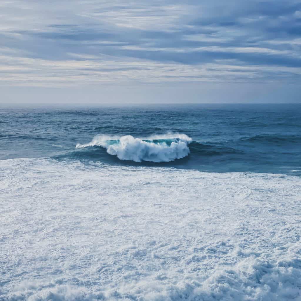 white sea waves on white sand during daytime