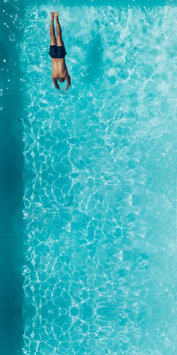 person about to dive on swimming pool