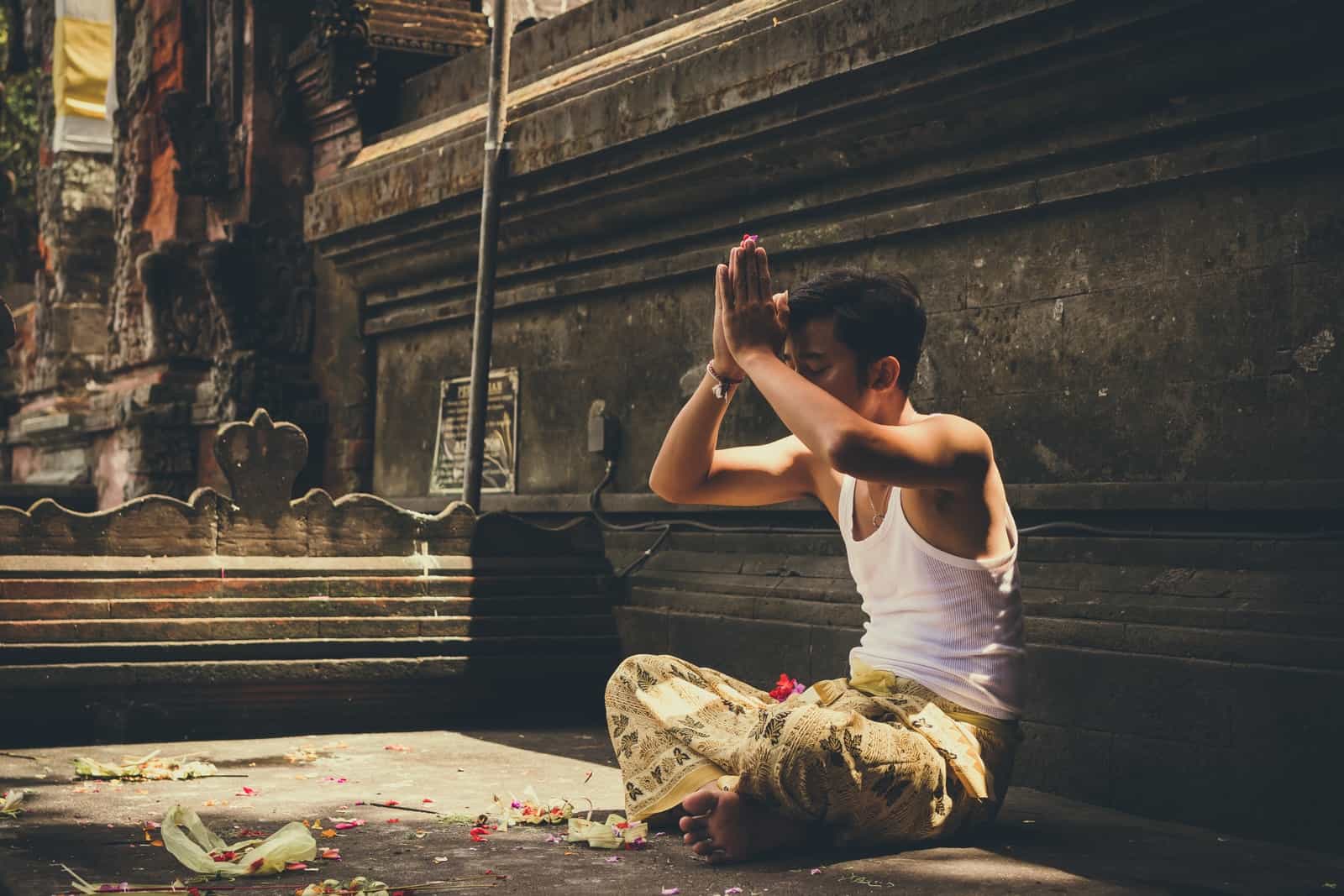 man in white tank top praying