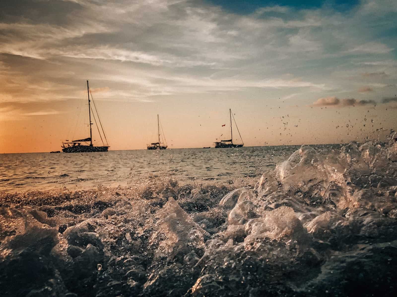 grayscale photo of sail boat on sea shore