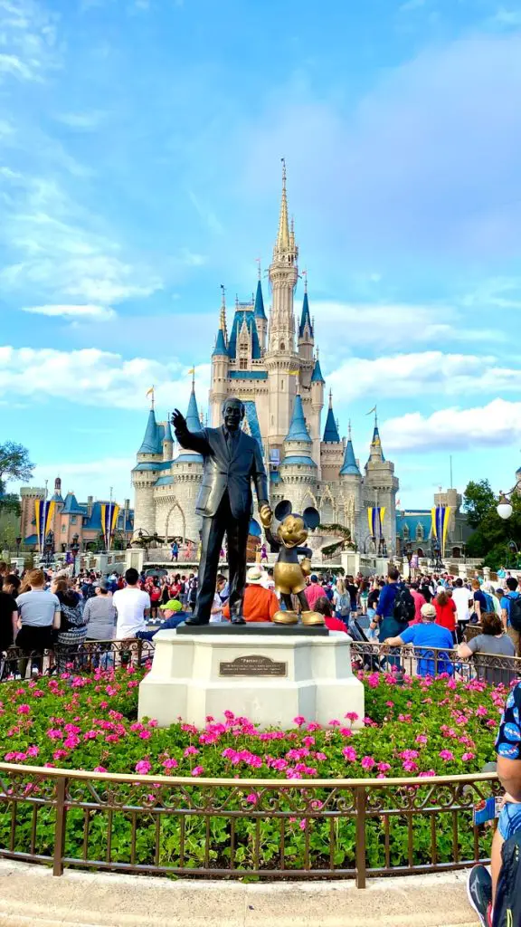 people walking on park near disney castle during daytime