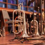 brass trumpet on brown wooden table