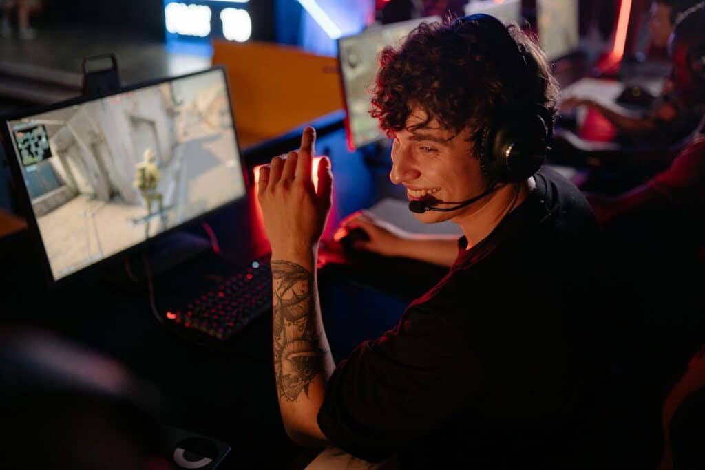 Curly Haired Man in Black Shirt Playing Computer Game