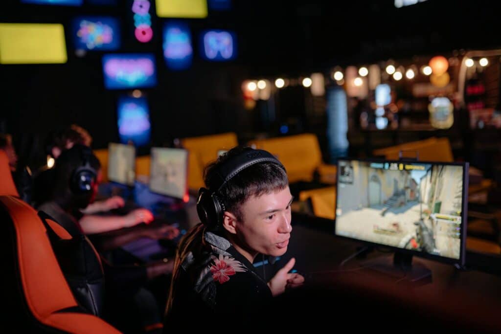 A Man Wearing a Headset in Front of a Gaming Computer Screen