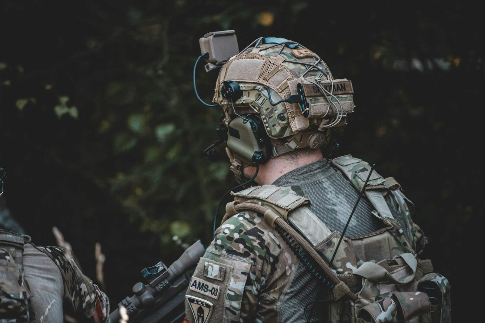 man in black and brown camouflage jacket wearing helmet and helmet