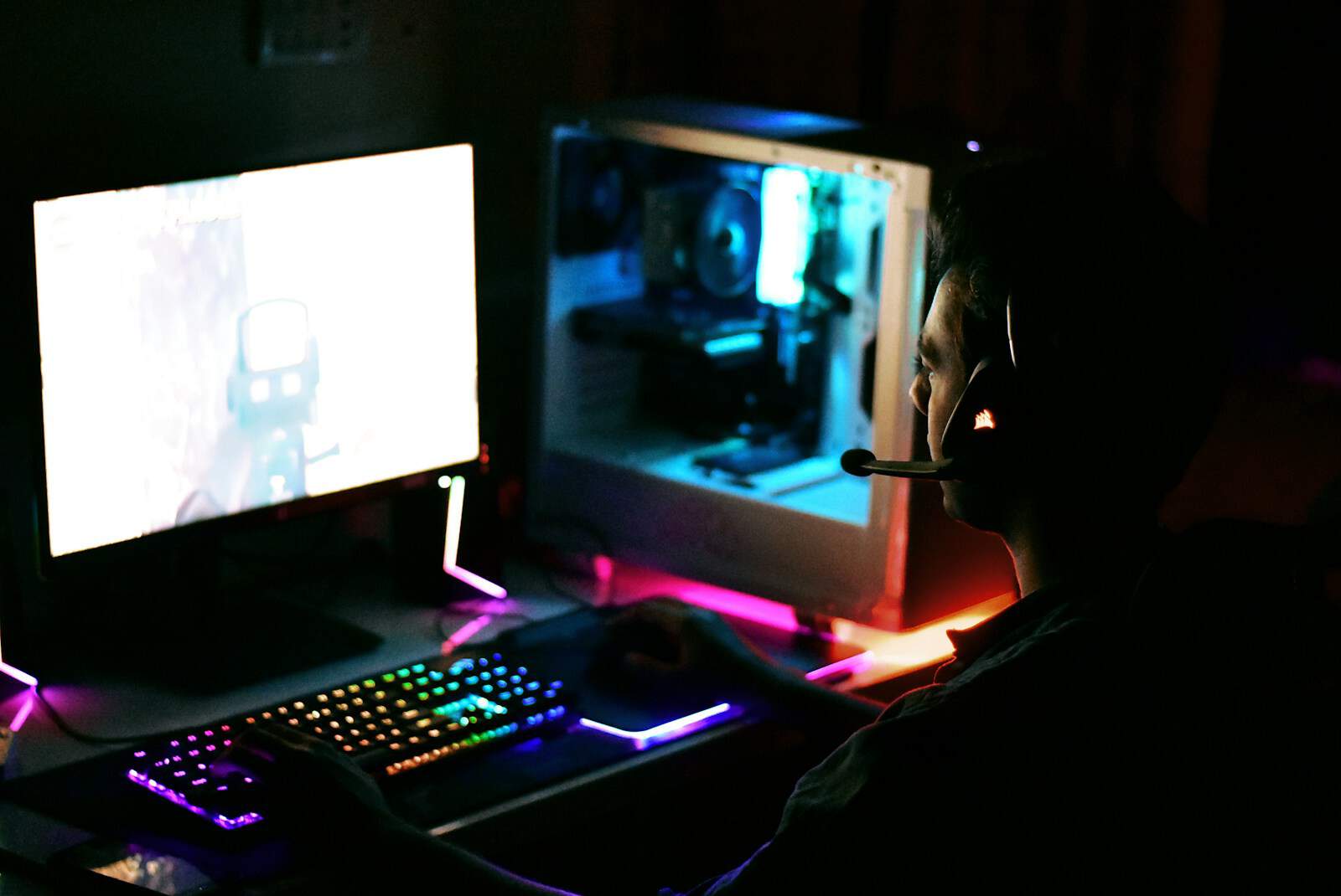 a person wearing a mask sitting in front of a computer